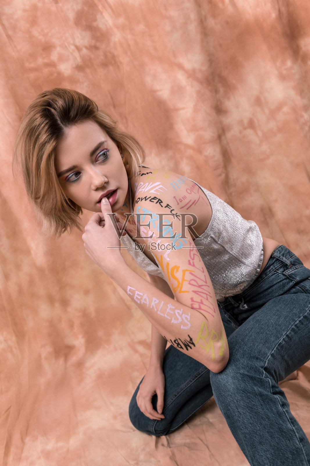 漂亮诱人的年轻女人在抚摸她的嘴唇照片摄影图片