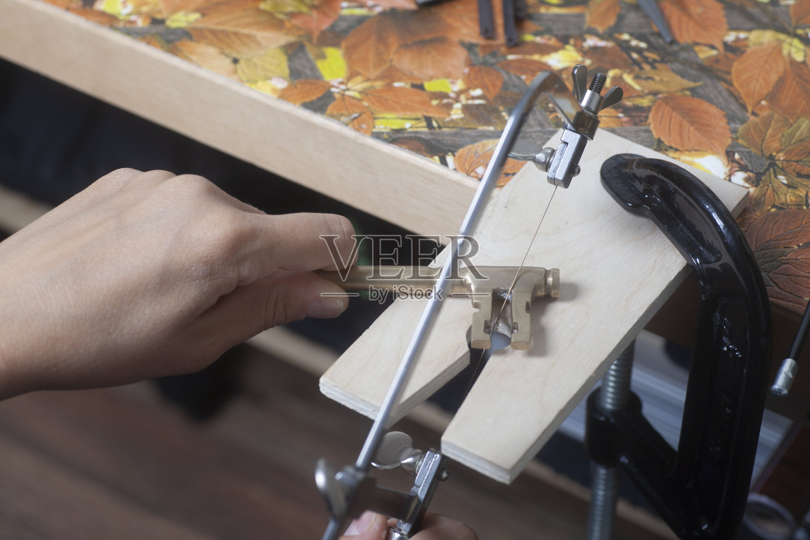 用珠宝锯工作的珠宝商。照片摄影图片