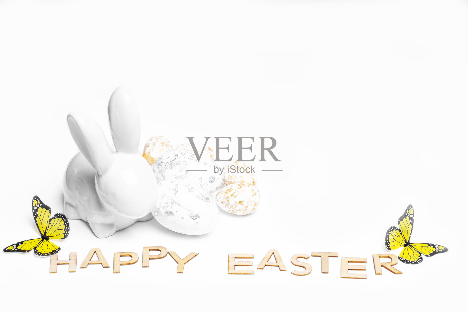 复活节快乐。复活节白色的兔子在白色的背景与复活节彩蛋。带有复活节兔子的复活节贺卡。照片摄影图片