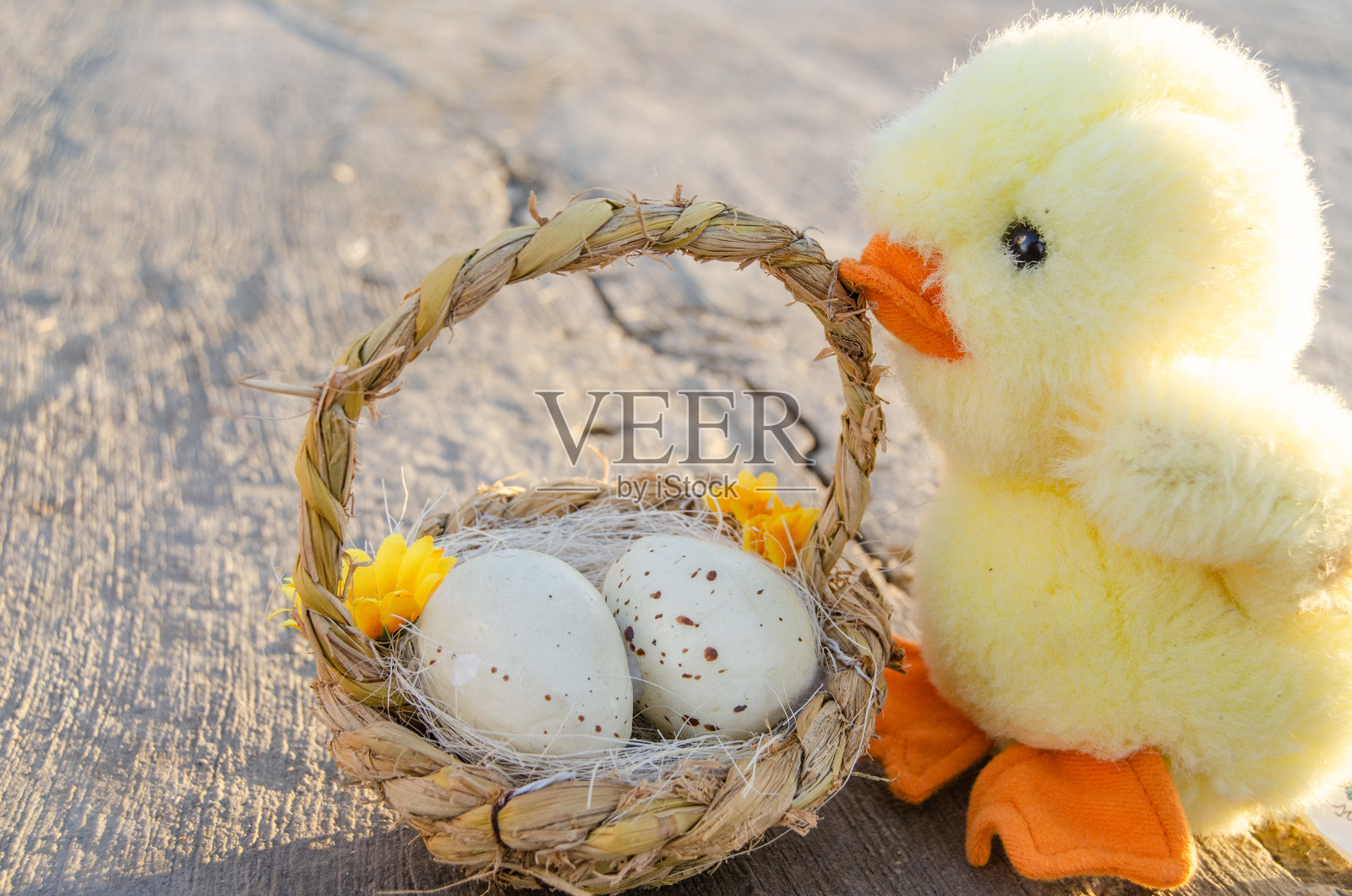 可爱的小小鸡玩具和篮子上有两个复活节蛋的石头小路-复活节的概念照片摄影图片