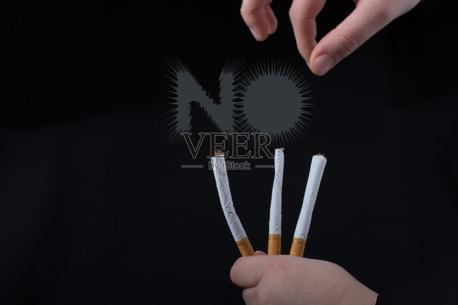 黑色背景上的手拿着香烟照片摄影图片