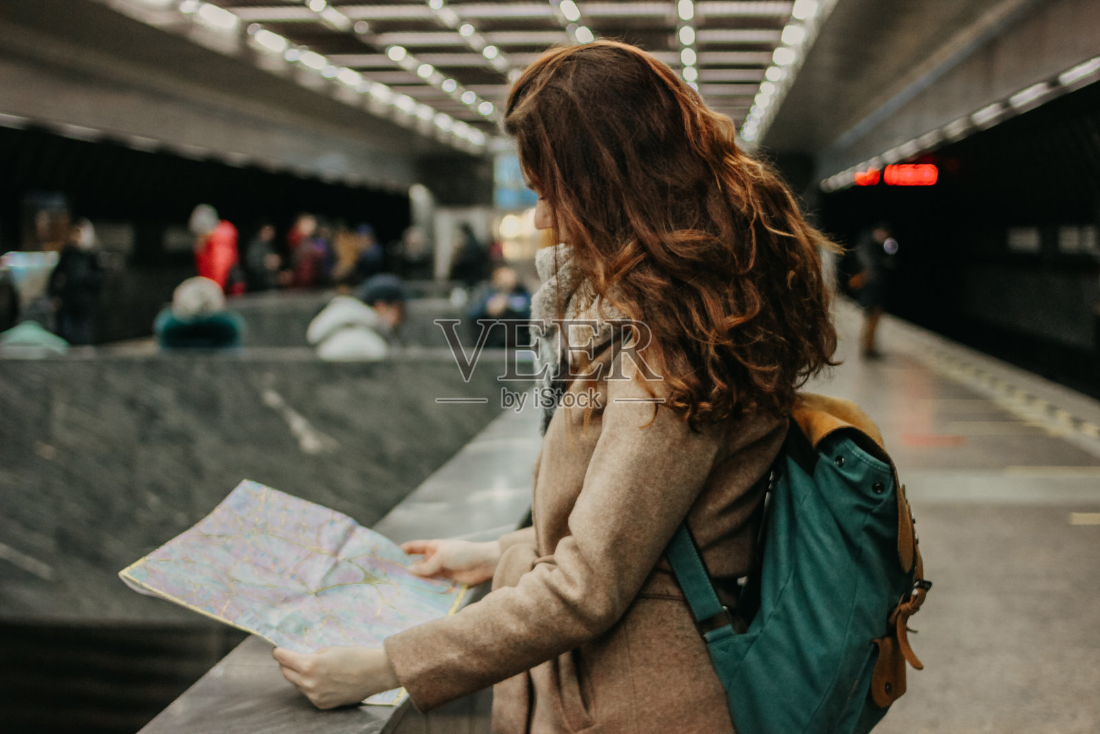年轻女子卷发红头发女孩旅行者背包和地图在地铁照片摄影图片