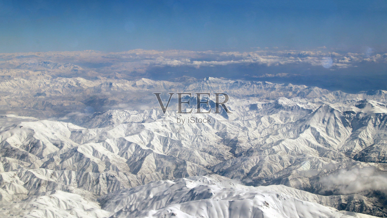 从飞机窗口看，云，山，天空和海洋是蓝色的照片摄影图片