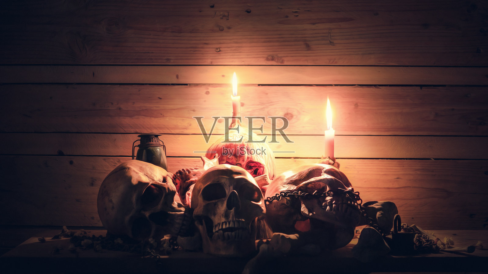 虎门头骨与点燃的蜡烛和古老的链条在木桌和木制背景在黑暗的复古色调照片摄影图片