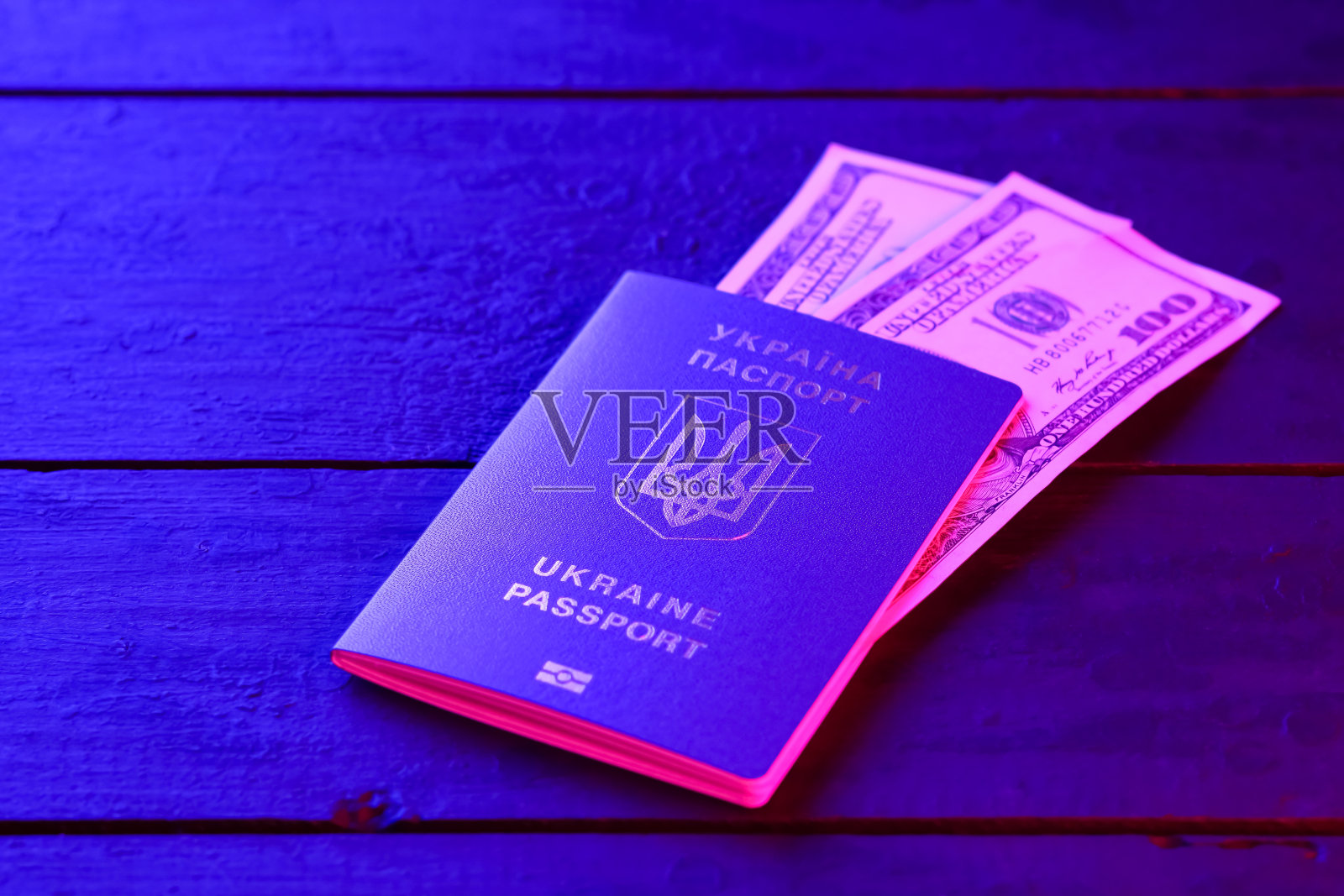 乌克兰生物识别护照和美元。在黑板上的乌克兰国际护照，俯视图。蓝光出国旅行证件照片摄影图片