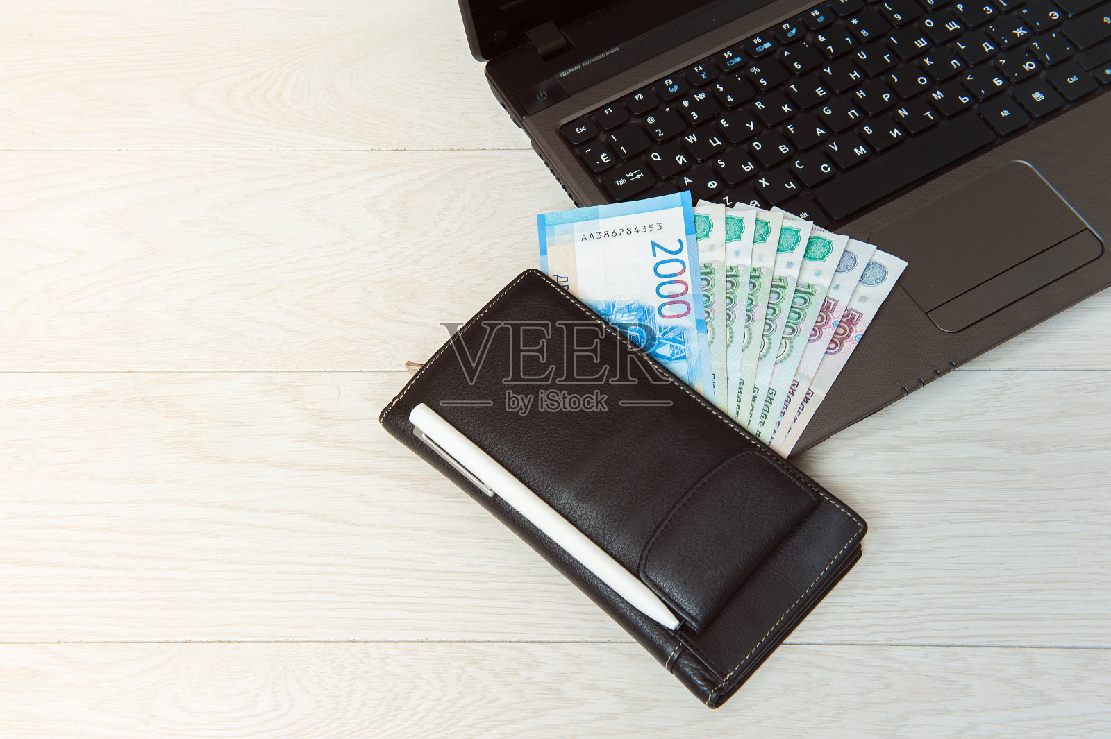 笔记本电脑键盘上的钱。照片摄影图片