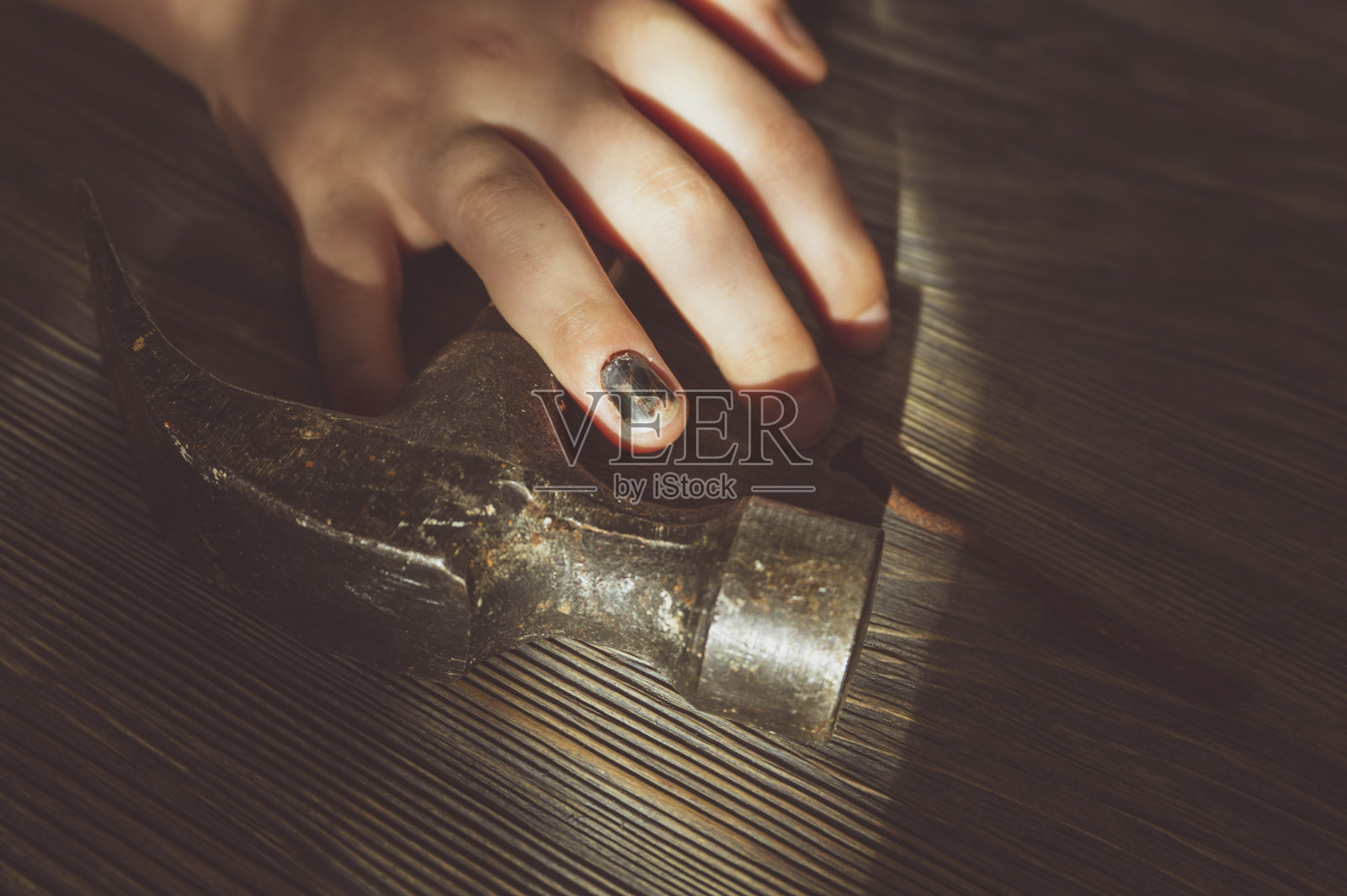 手与黑色的拇指指甲在一个锤子照片摄影图片