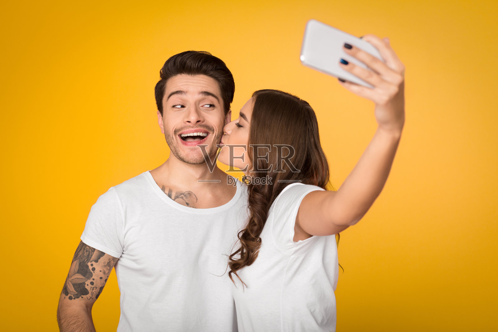 一对可爱的夫妇在黄色背景上自拍照片摄影图片