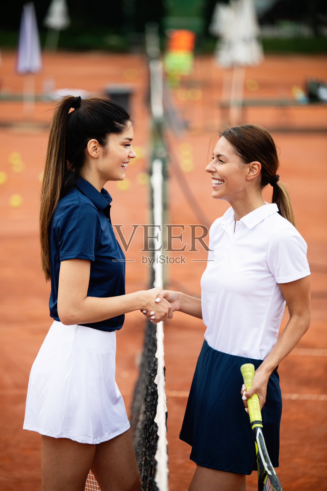 女子网球运动员在打完网球比赛后握手。公平竞赛、体育概念。照片摄影图片