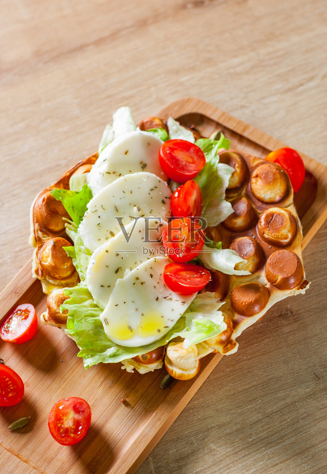 香港气泡华夫三明治配马苏里拉芝士和蔬菜放在木桌的背景上照片摄影图片