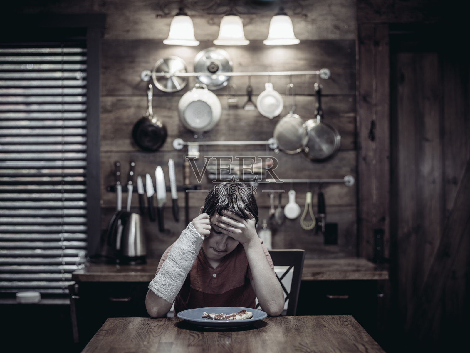 十几岁的男孩，手臂上缠着石膏照片摄影图片
