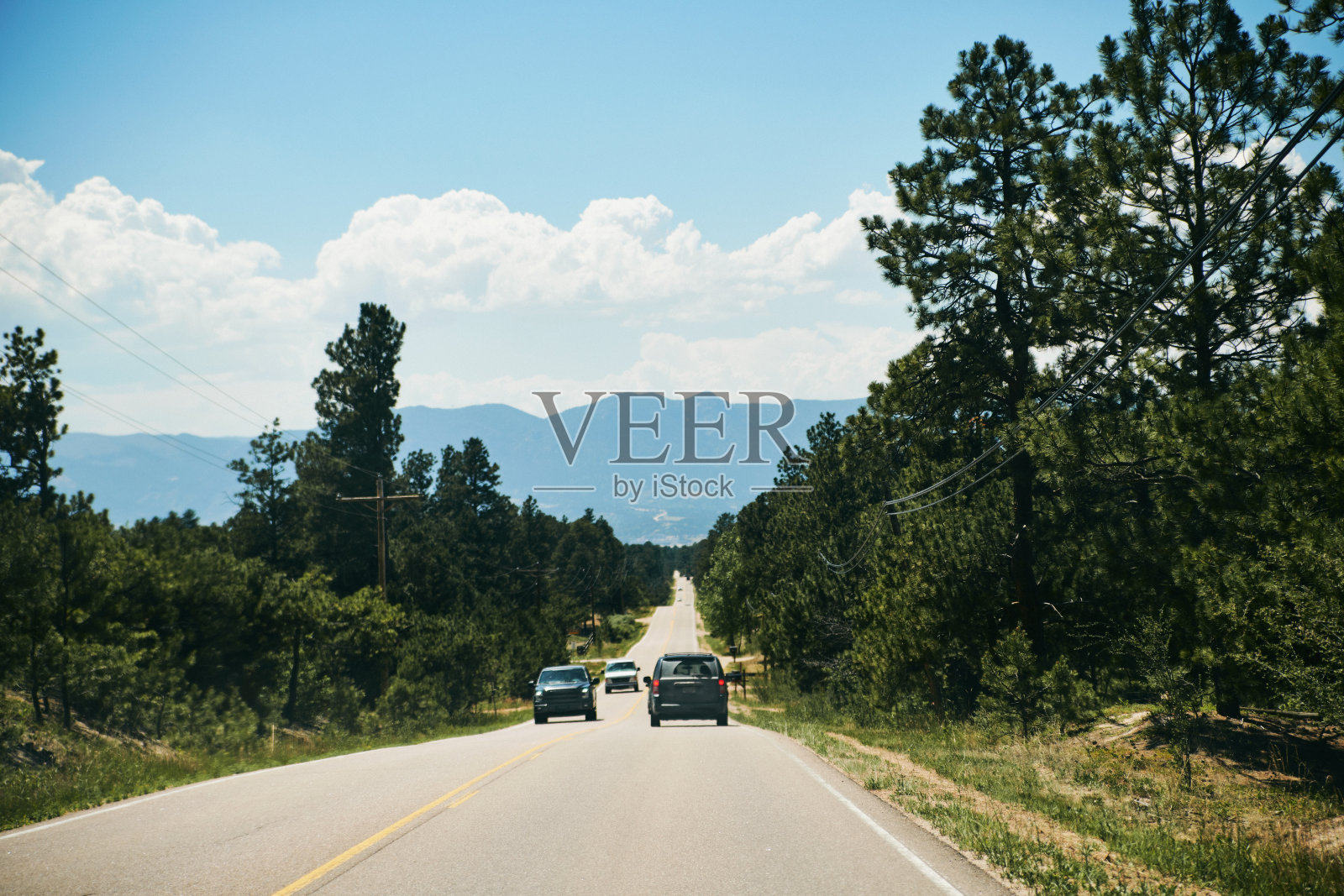 车辆在树木环绕的道路上行驶。乘客的观点照片摄影图片
