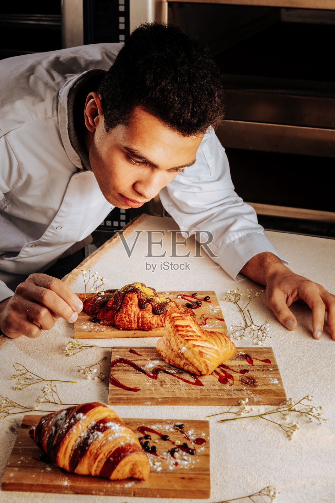 面包师为客户装饰三款令人惊叹的甜点照片摄影图片