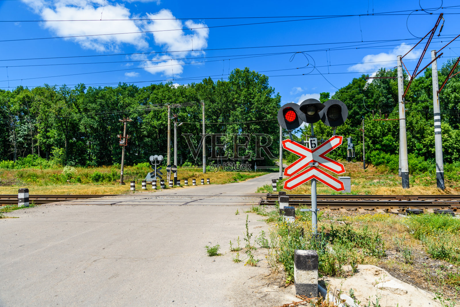 铁路道口前有铁路道口标志和闪烁信号灯照片摄影图片