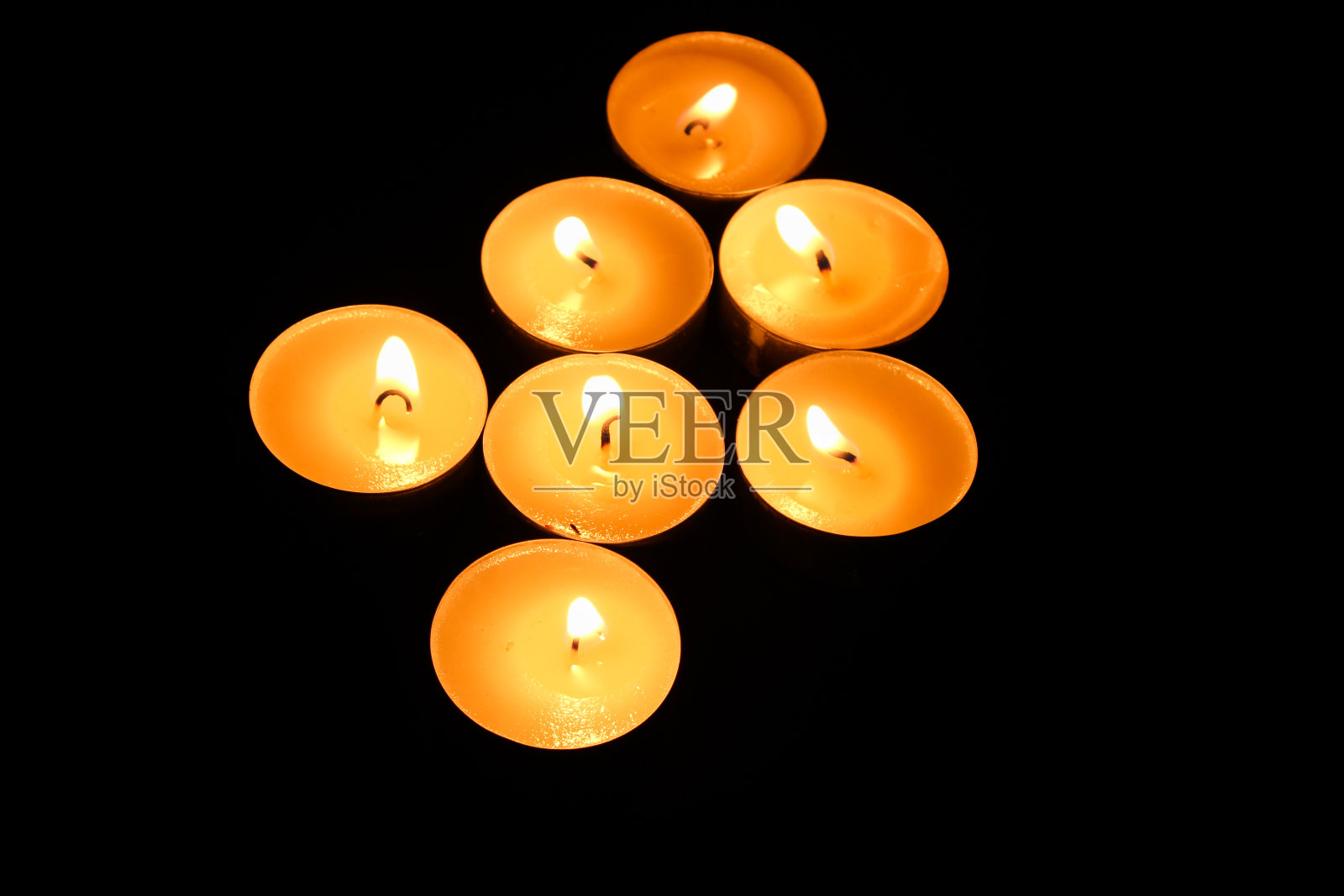 燃烧的茶蜡烛孤立在黑色背景照片摄影图片