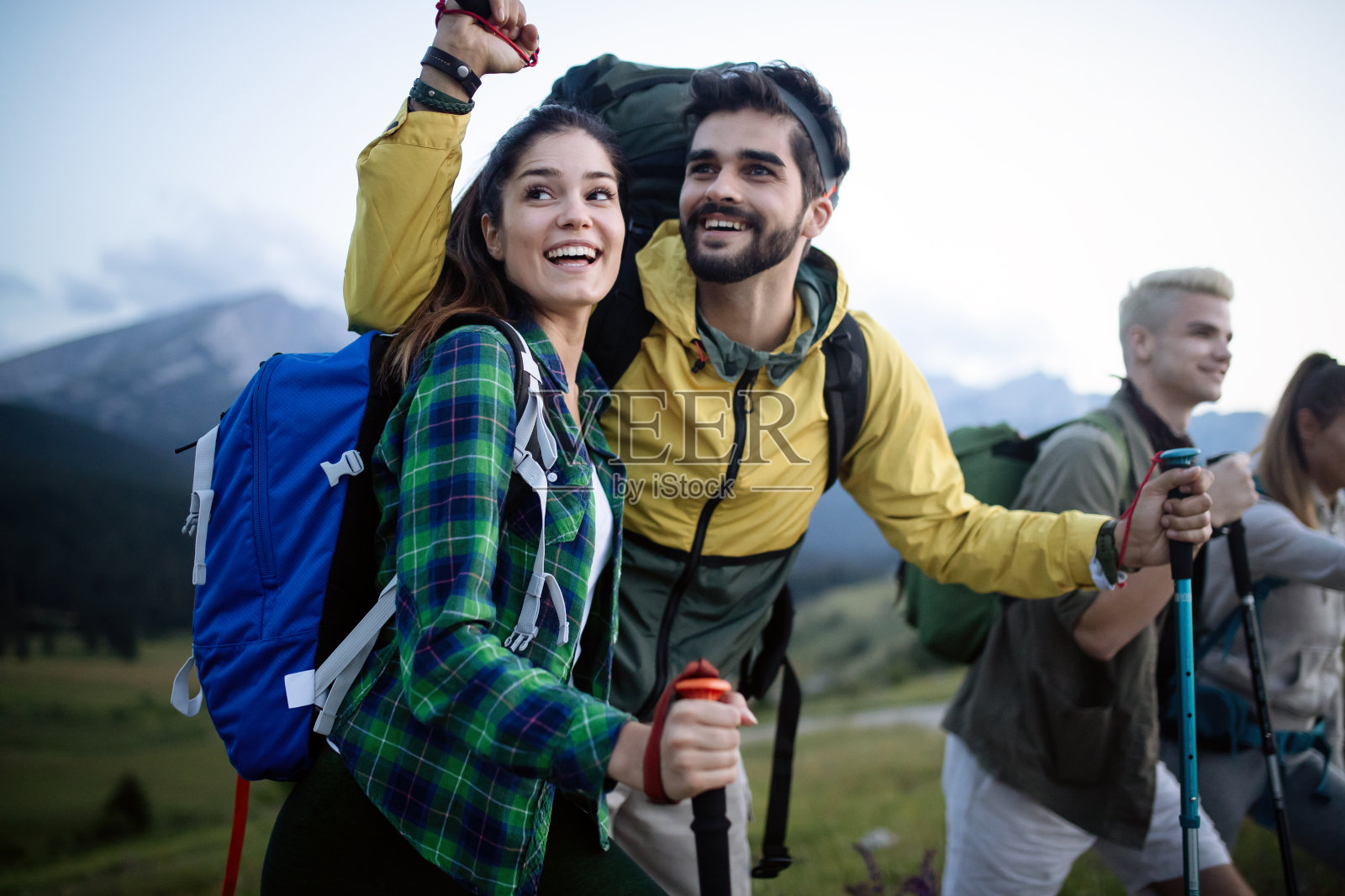 和朋友一起徒步旅行很有趣。一群背着背包一起走路的年轻人照片摄影图片