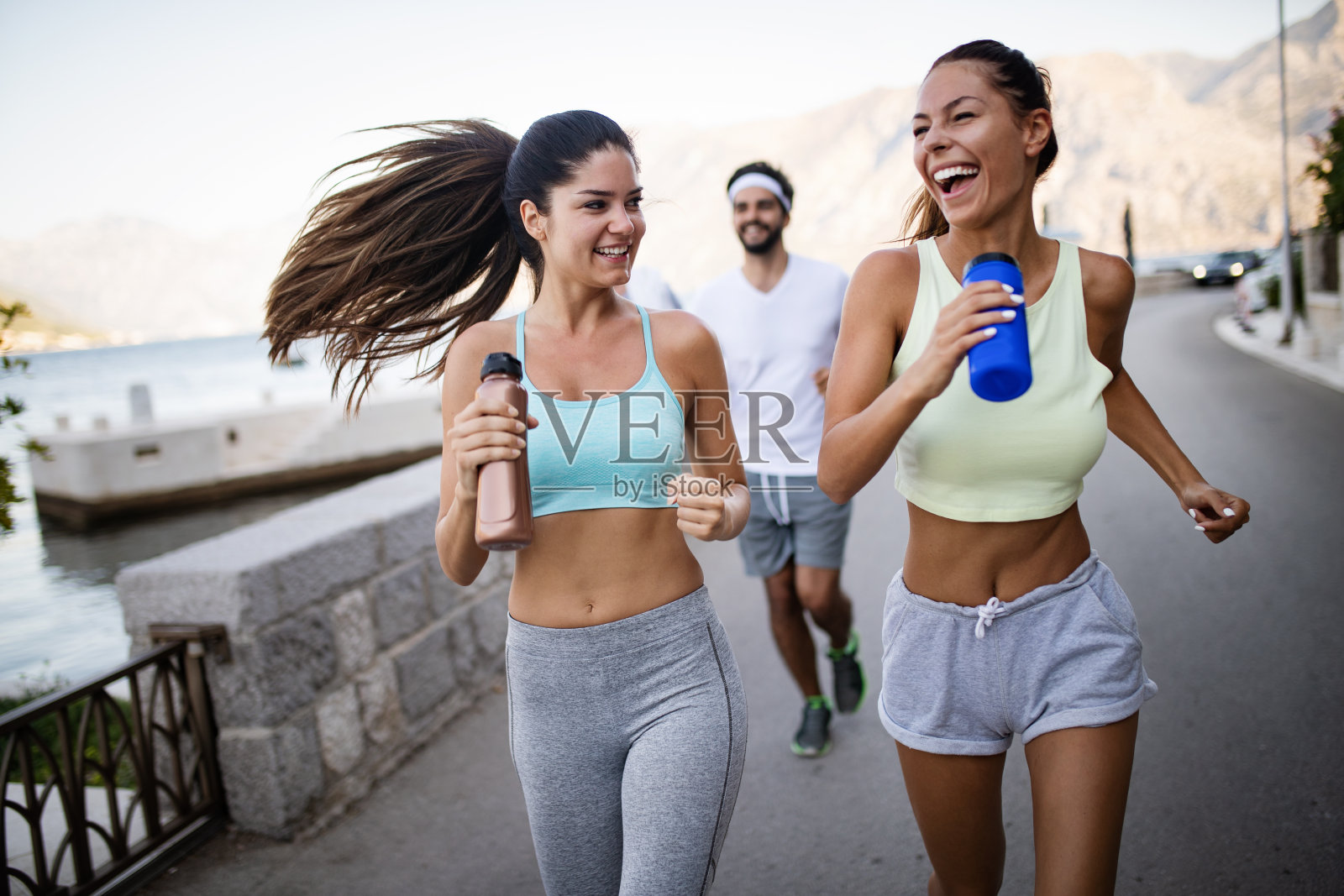 一群年轻人朋友在海边户外跑步照片摄影图片