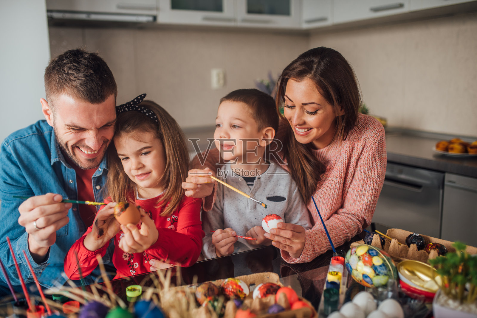 孩子们和父母一起装饰复活节彩蛋照片摄影图片