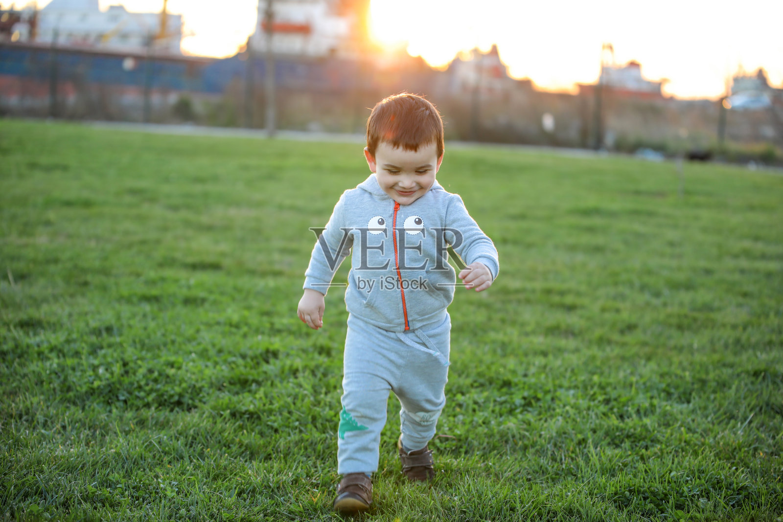 婴儿的第一步。独立的第一步。在公园里跑步的小孩。照片摄影图片
