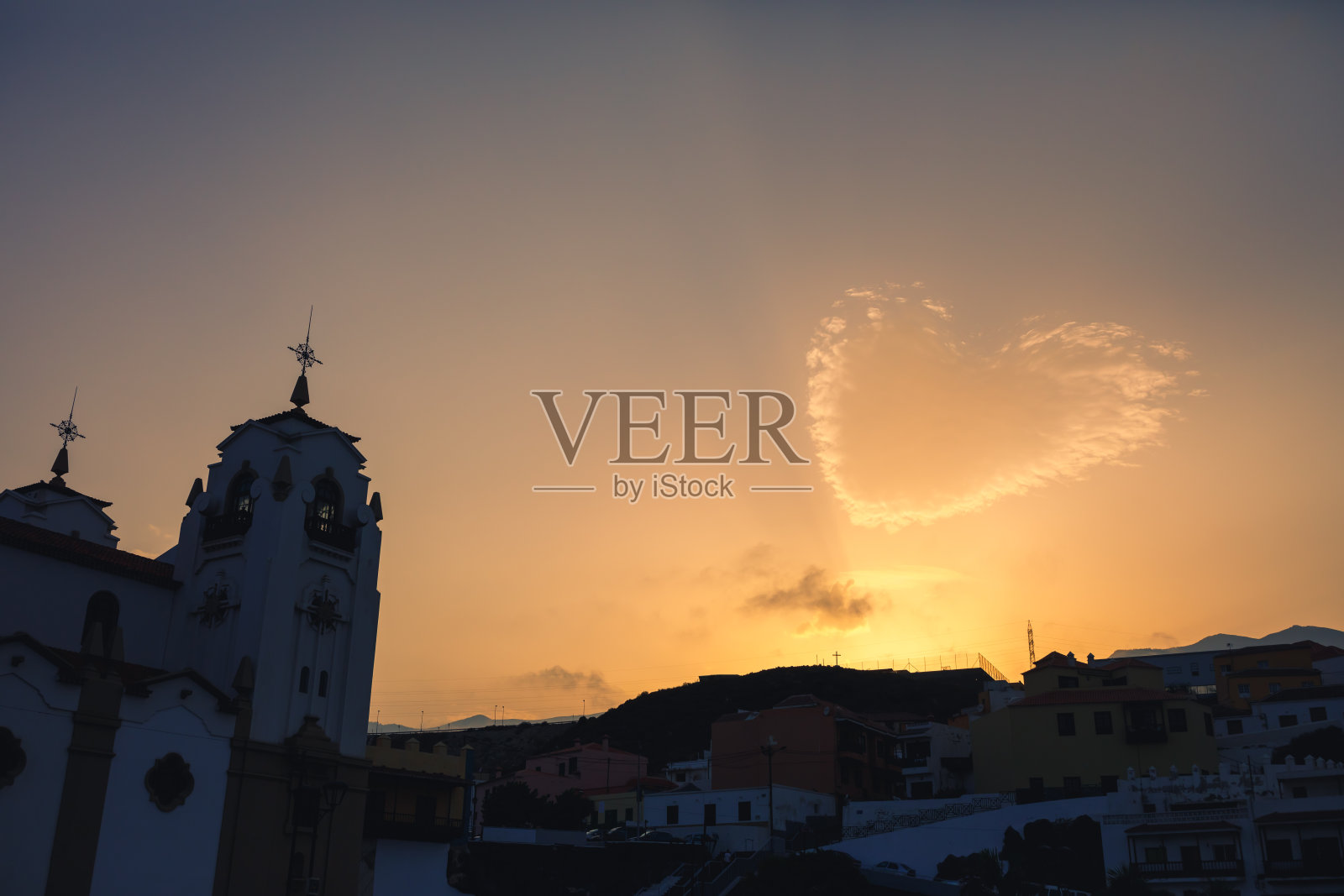 心形的云和教堂在日落的剪影照片摄影图片