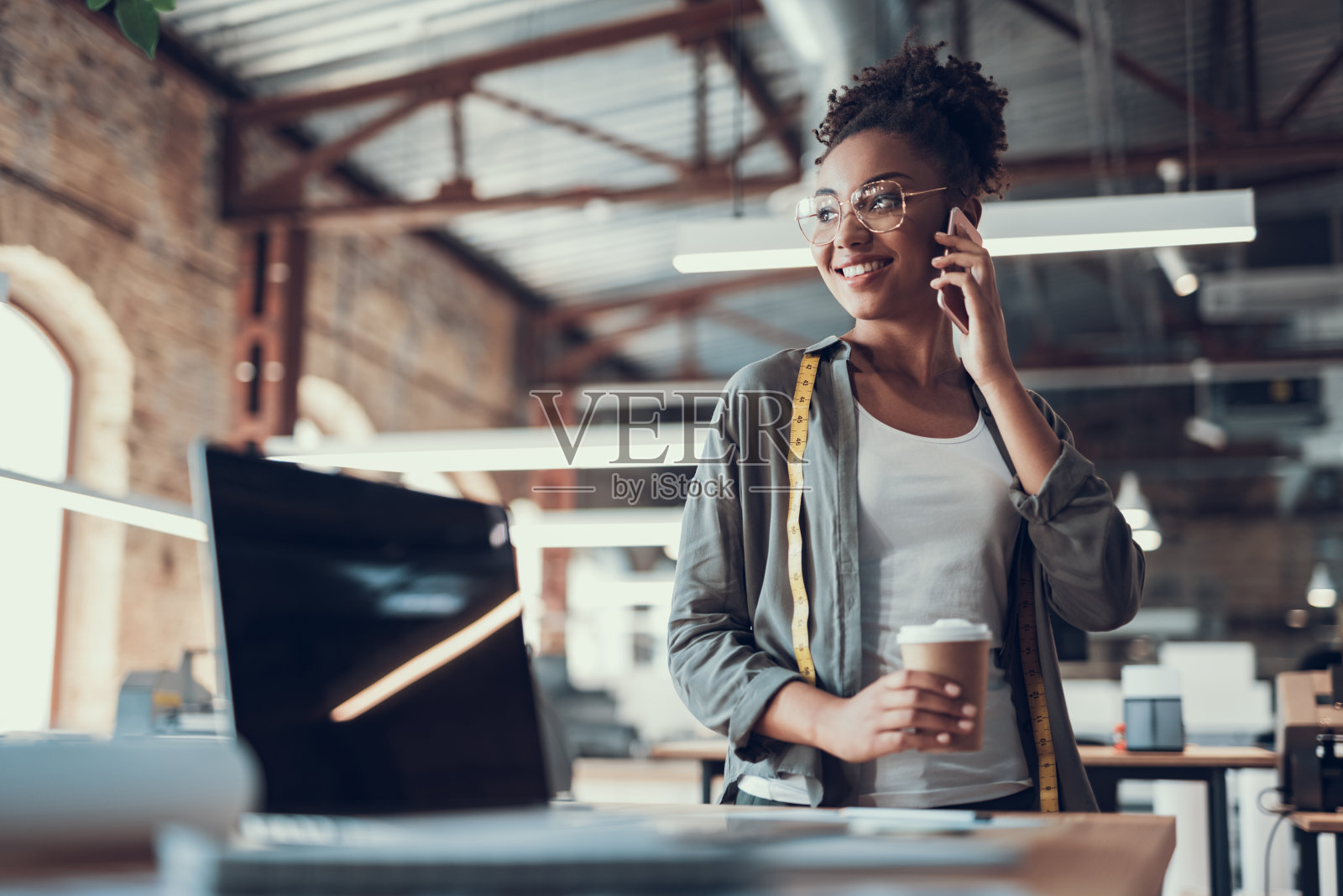 迷人的非洲裔美国女孩在工作时打电话照片摄影图片