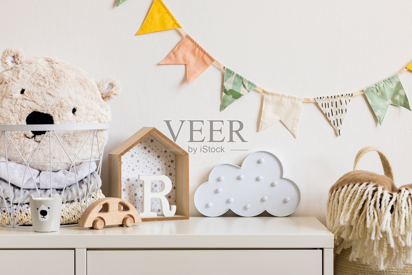 现代化的斯堪的纳维亚新生儿婴儿房模拟相框，木制汽车，毛绒犀牛和云彩。挂着棉旗和白星。简约舒适的内饰，白色的墙壁。真实的照片照片摄影图片
