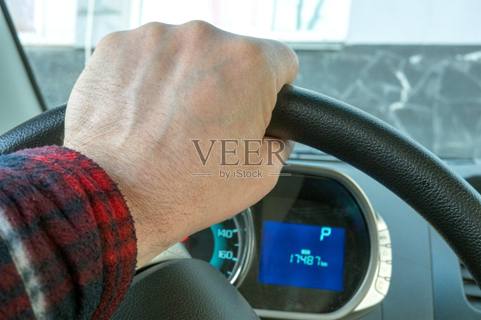 方向盘上的男人的手，汽车的仪表盘，它是静止的。照片摄影图片