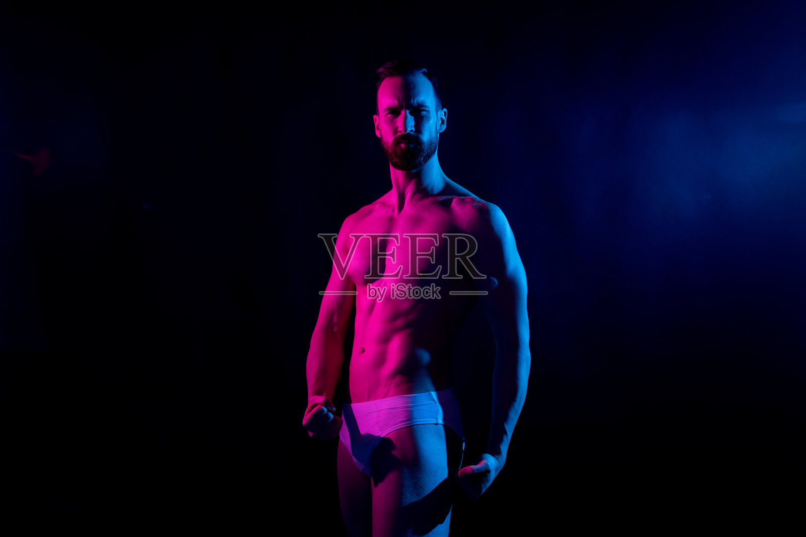 性感的男人在白色内衣在黑色的背景和凝胶照明照片摄影图片