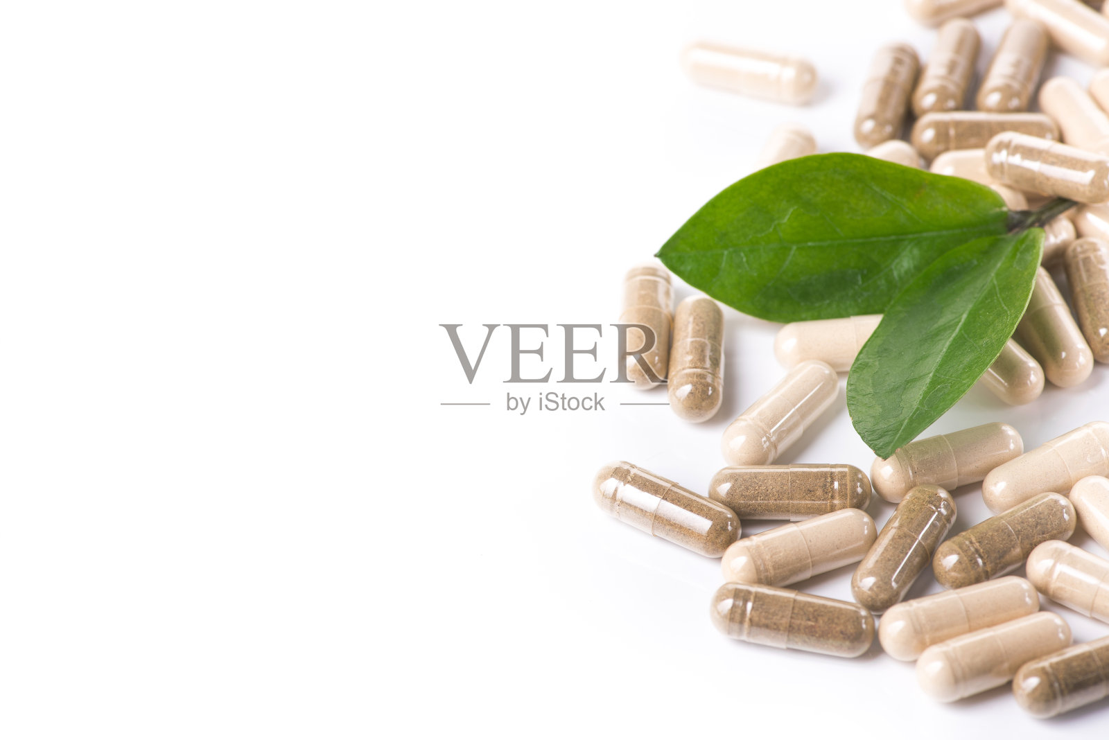 把绿叶分离的药丸和胶囊群照片摄影图片