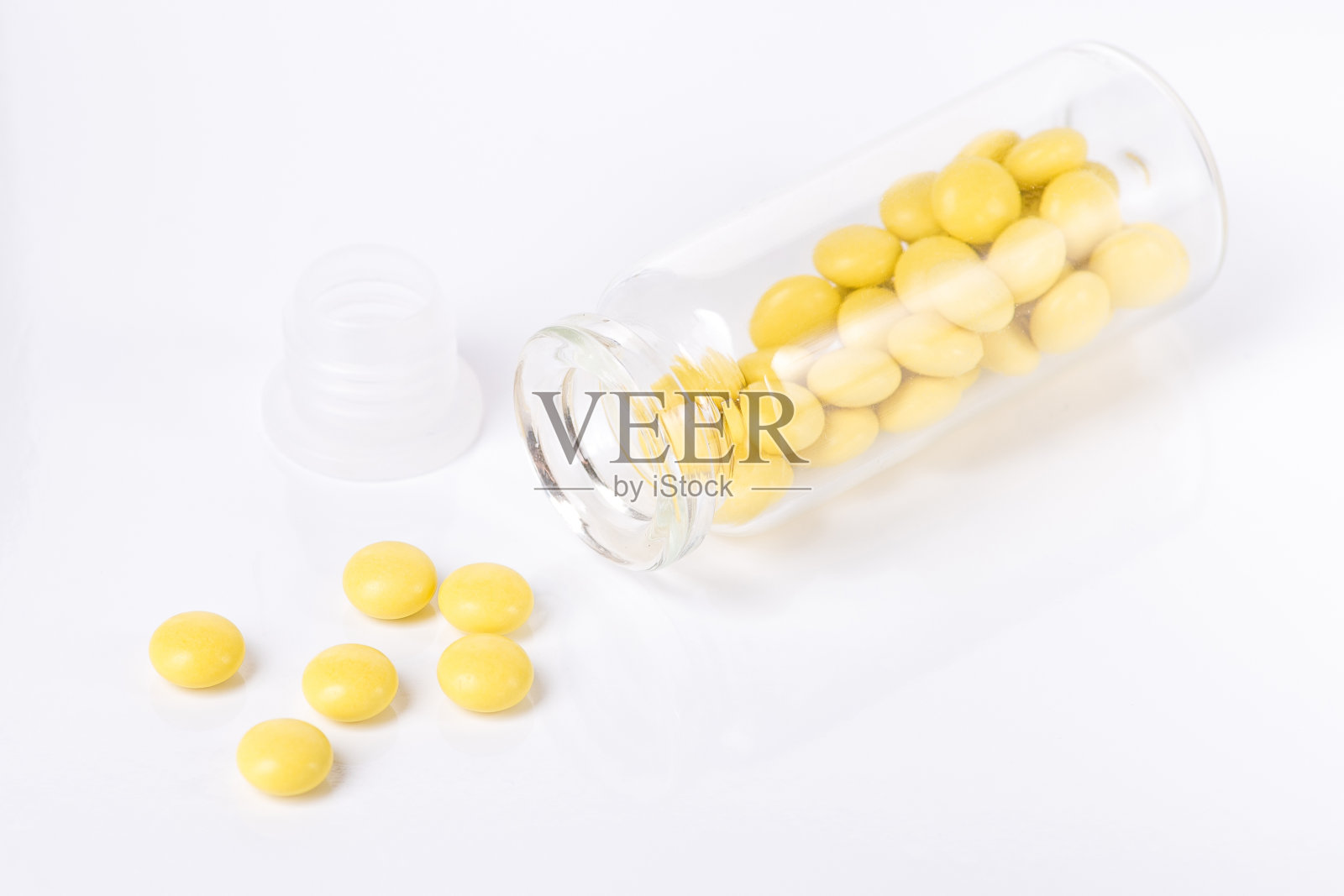 黄色药丸和玻璃瓶照片摄影图片