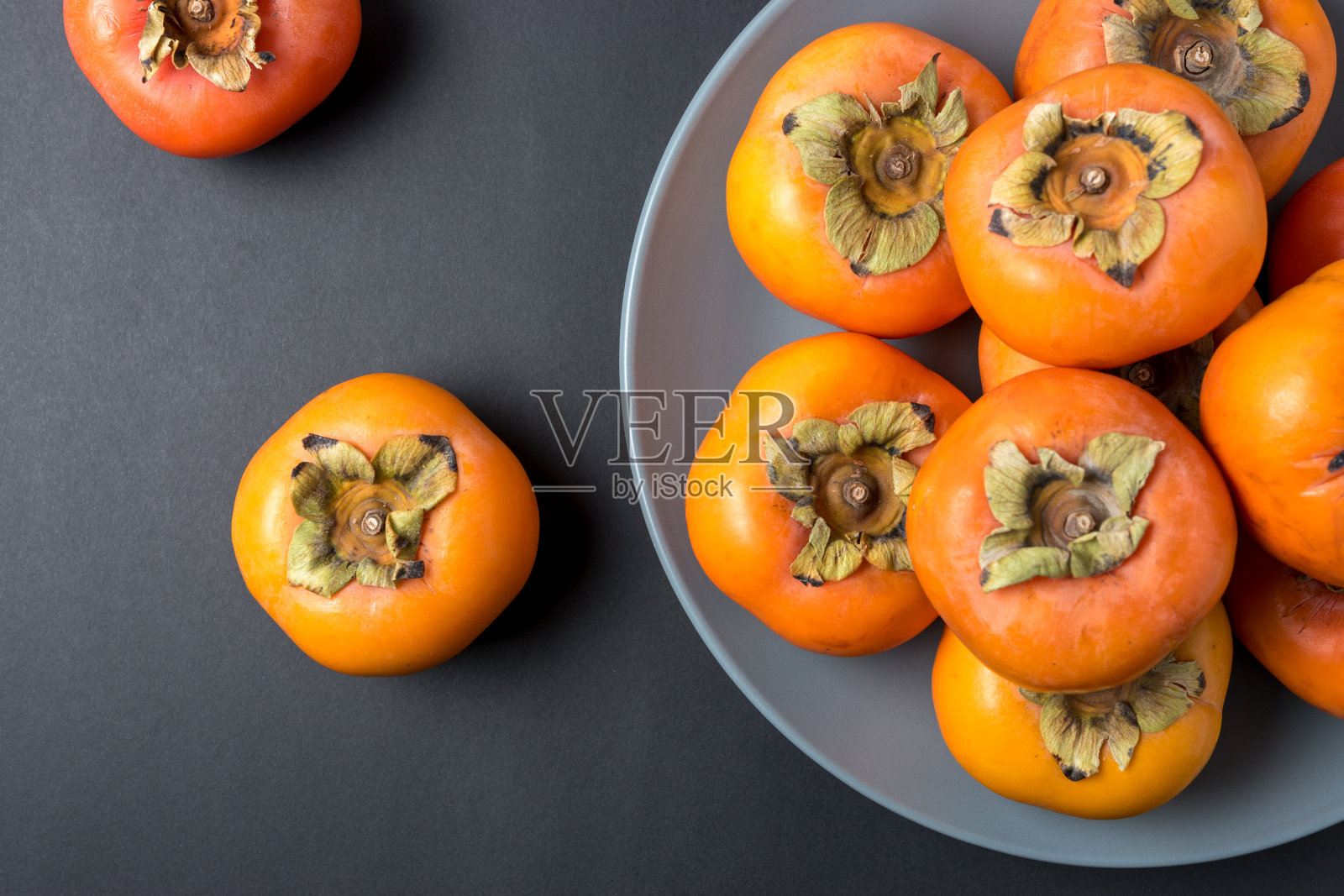 美味新鲜的柿子水果在黑色的背景。照片摄影图片