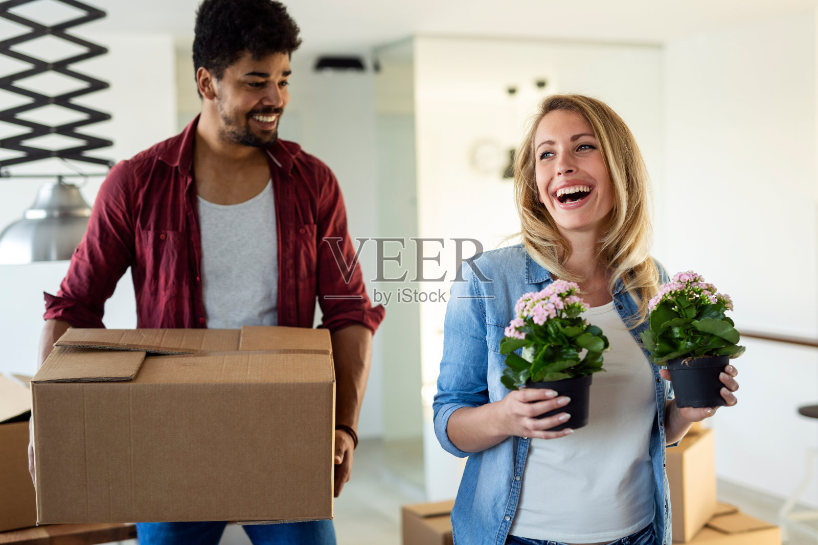 年轻夫妇打开纸板箱在新家搬家的概念照片摄影图片