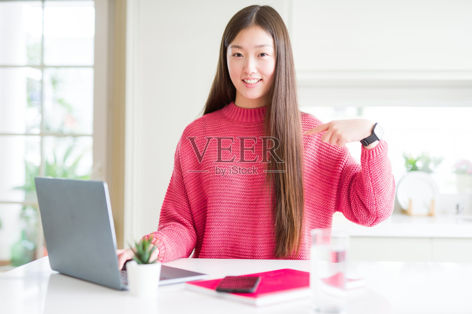 美丽的亚洲女人工作使用电脑笔记本电脑与惊讶的脸指向自己的手指照片摄影图片