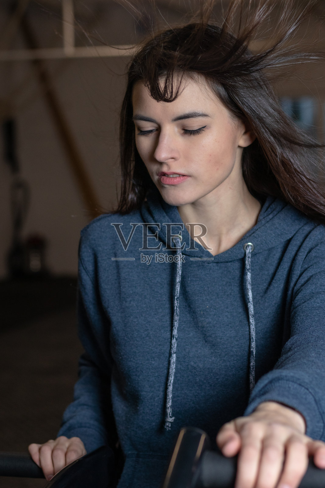 那个女孩正在健身房里骑健身自行车照片摄影图片