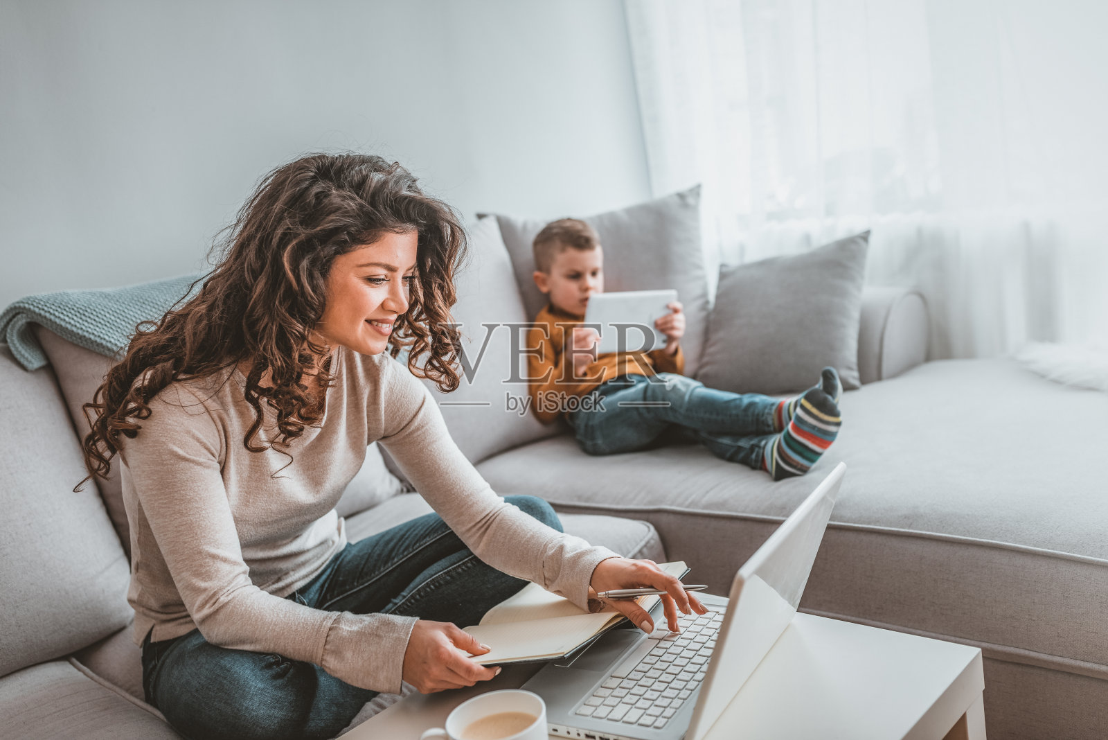 忙碌的年轻女子与儿子在家办公室照片摄影图片