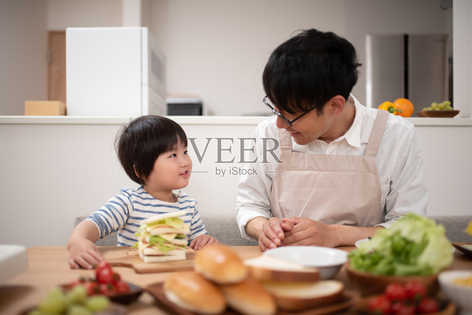 父亲和儿子在做三明治照片摄影图片