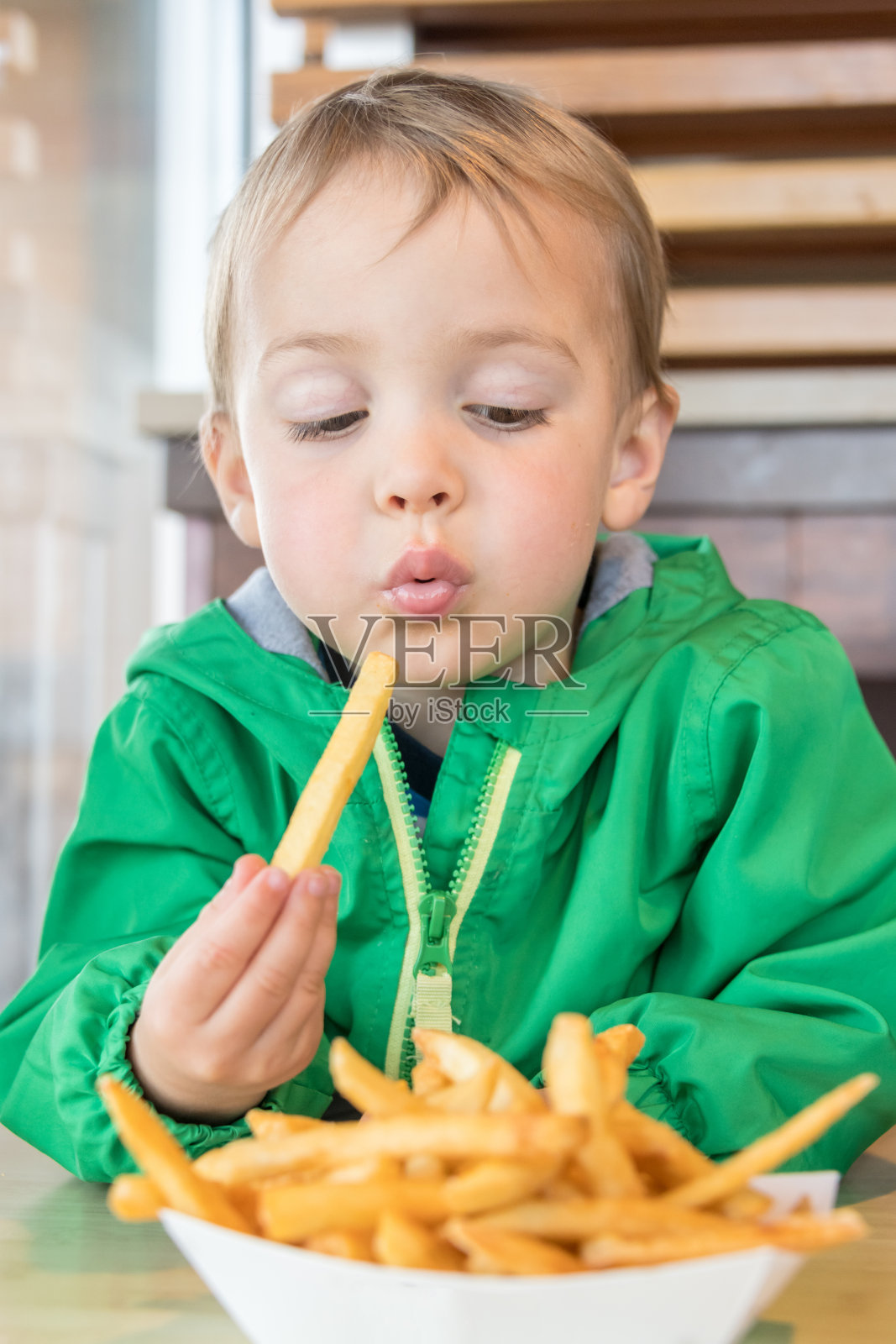 微笑的三岁的孩子，他的舌头在吃冰淇淋照片摄影图片