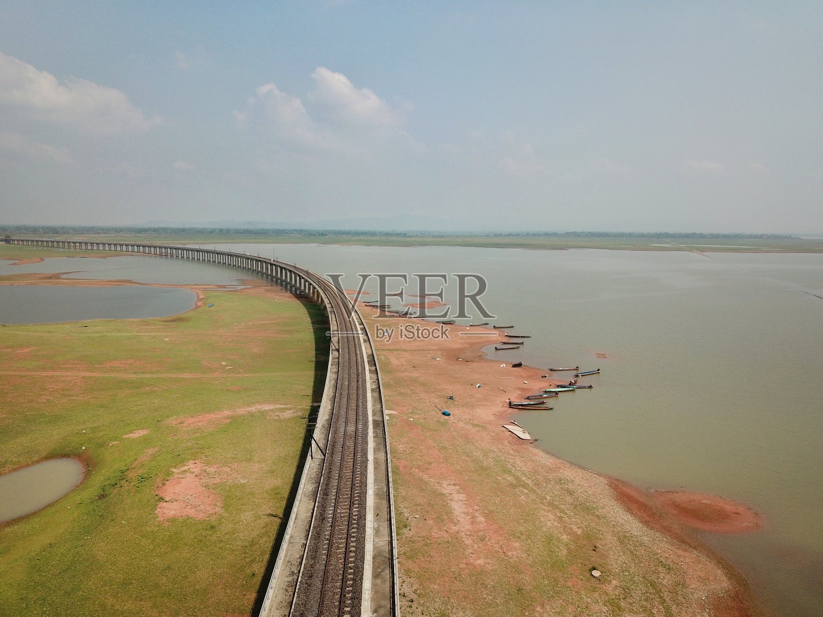 泰国罗布里省巴沙克卓拉西大坝水库上方的铁路轨道。照片摄影图片