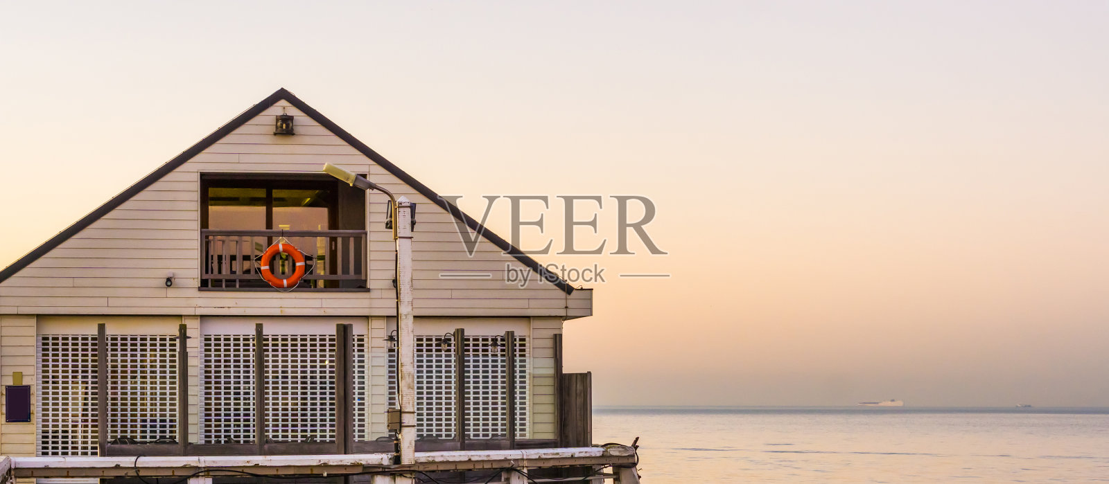 比利时布兰肯伯奇码头上的白色海滩房子，日落时比利时海岸的建筑照片摄影图片