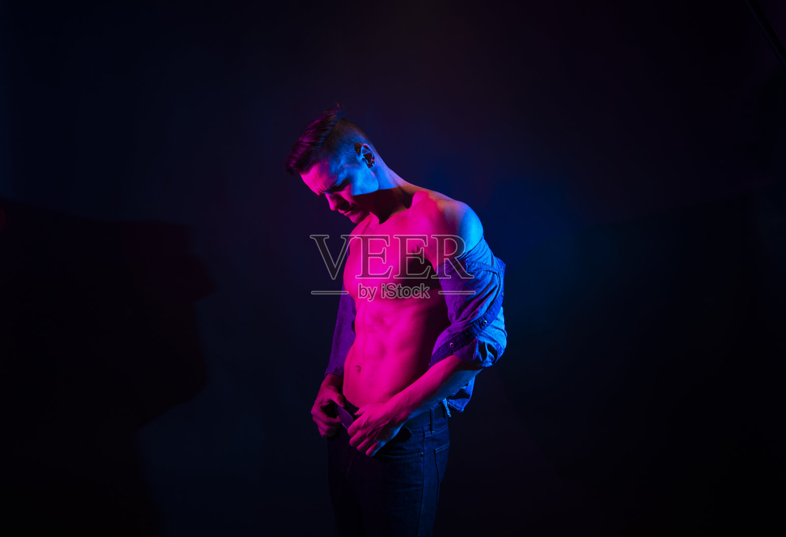 帅气的男性穿着一件解开的蓝色衬衫，感觉很性感照片摄影图片