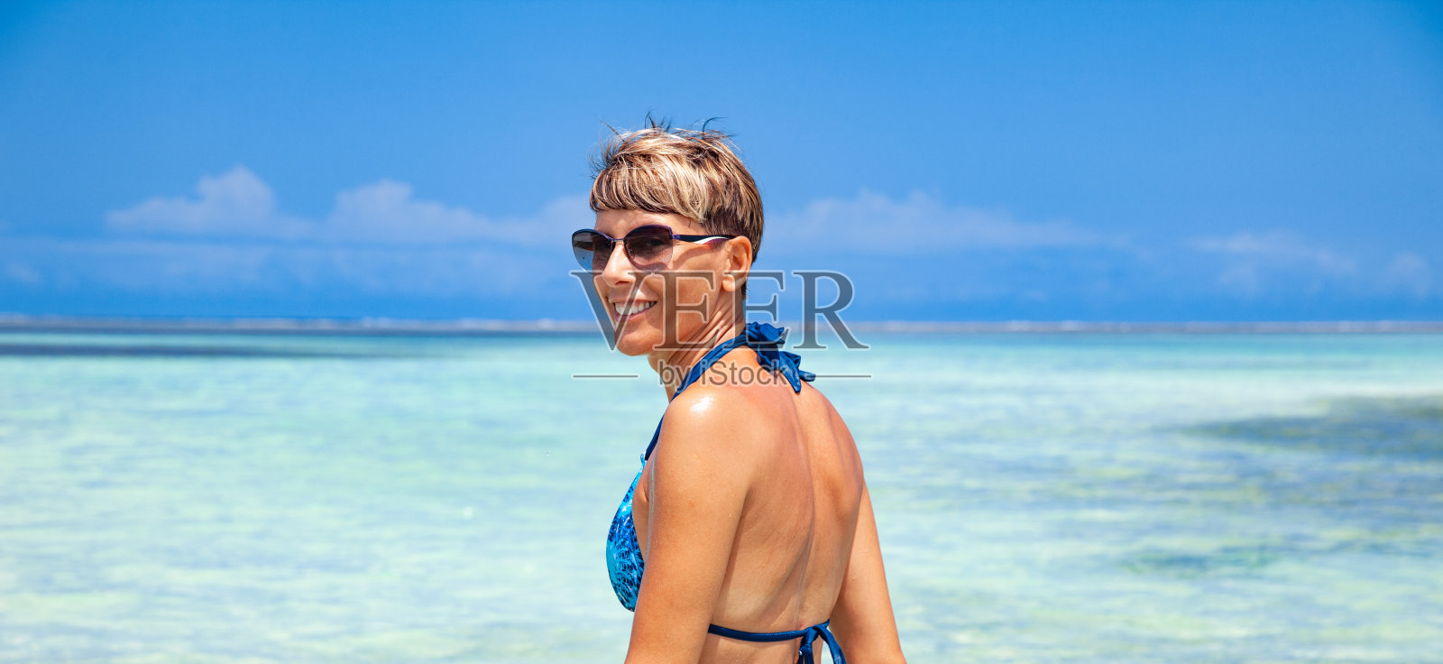 微笑的成年妇女在海边享受暑假照片摄影图片