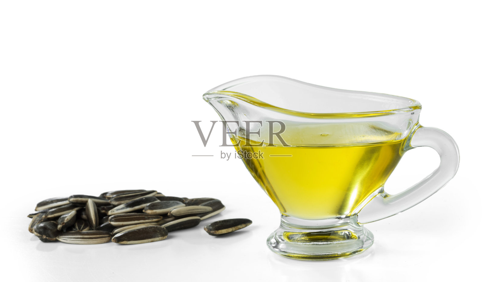 向日葵油在一个玻璃盘子和一把葵花籽孤立在白色的背景照片摄影图片