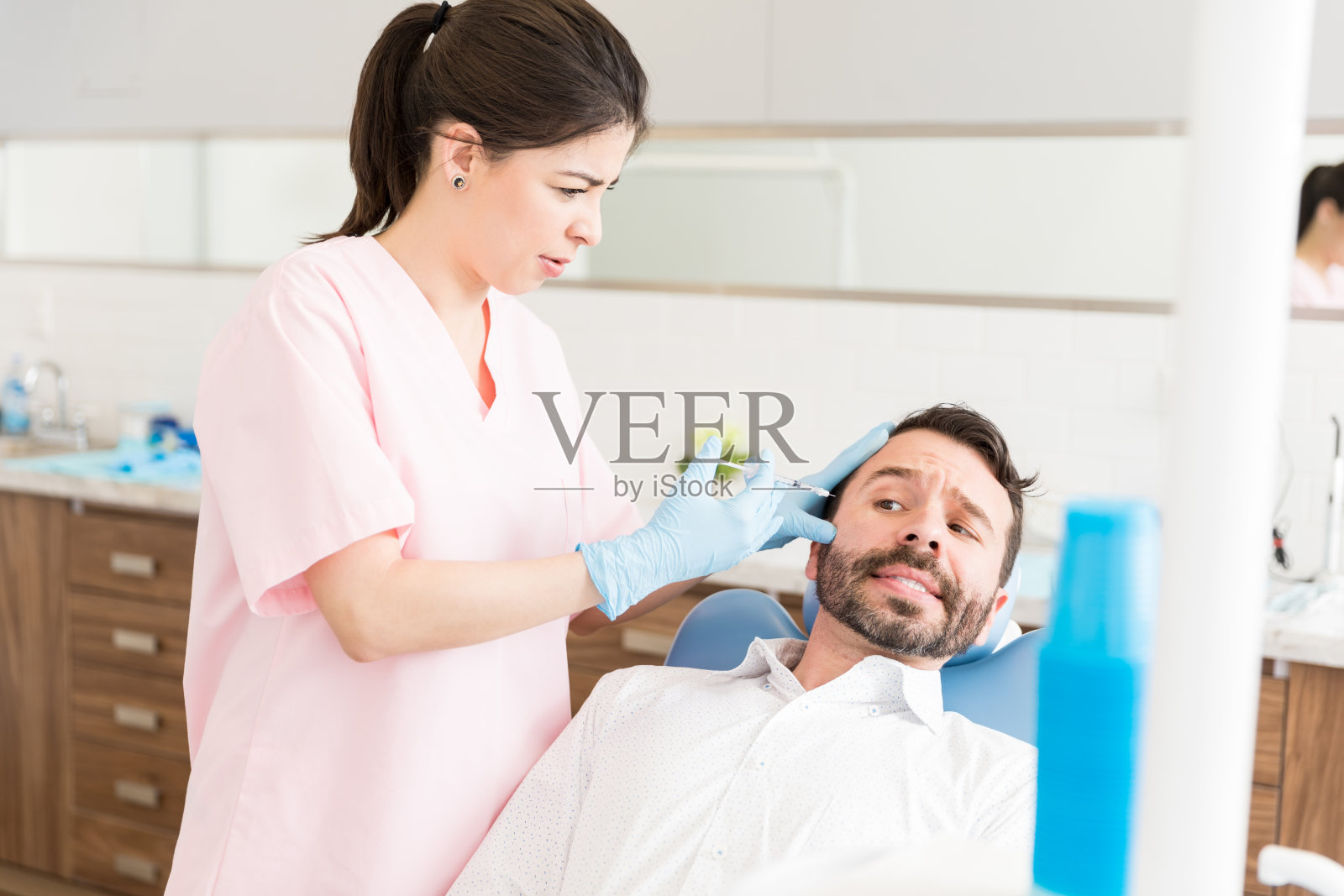 害怕的男人接受抗皱注射照片摄影图片