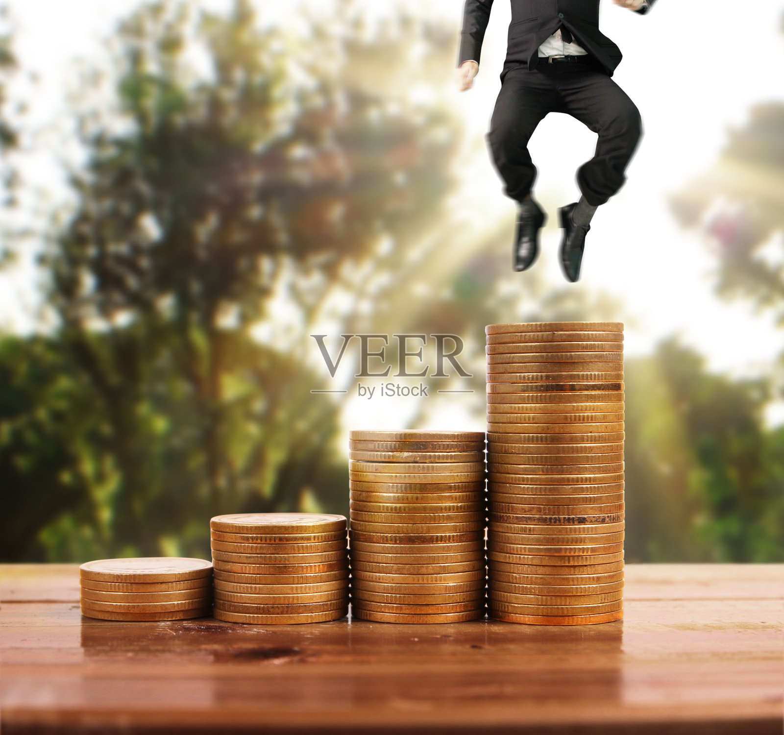 商人走在一堆硬币上，这就是成功照片摄影图片