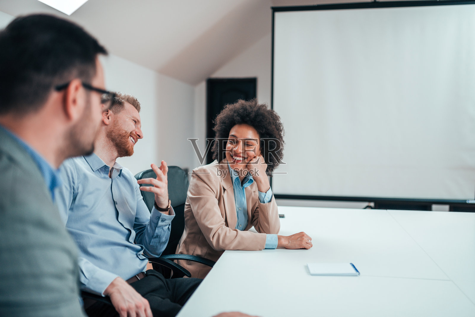 同事们在办公室谈笑风生。照片摄影图片