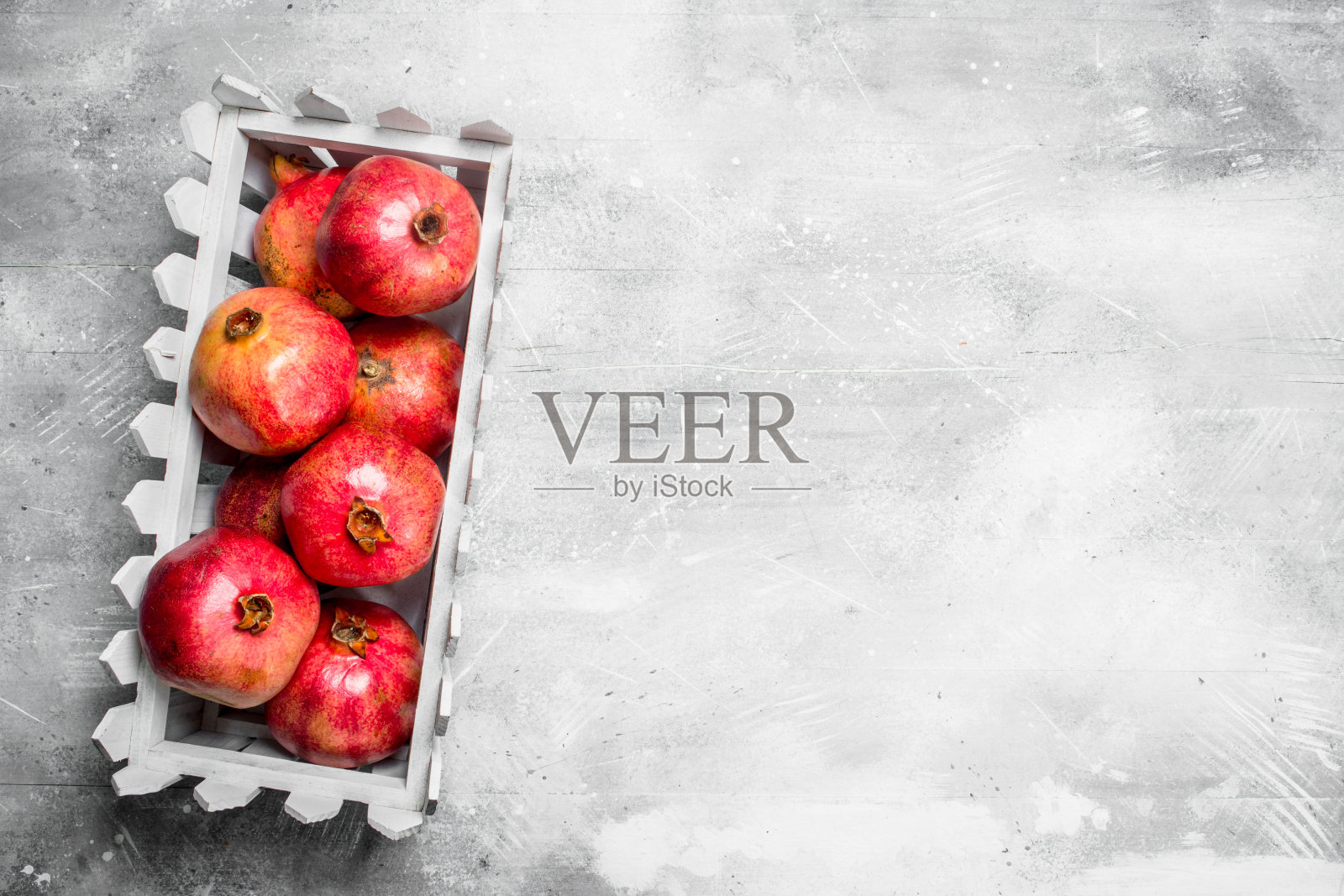 塑料盒子里的红石榴。照片摄影图片