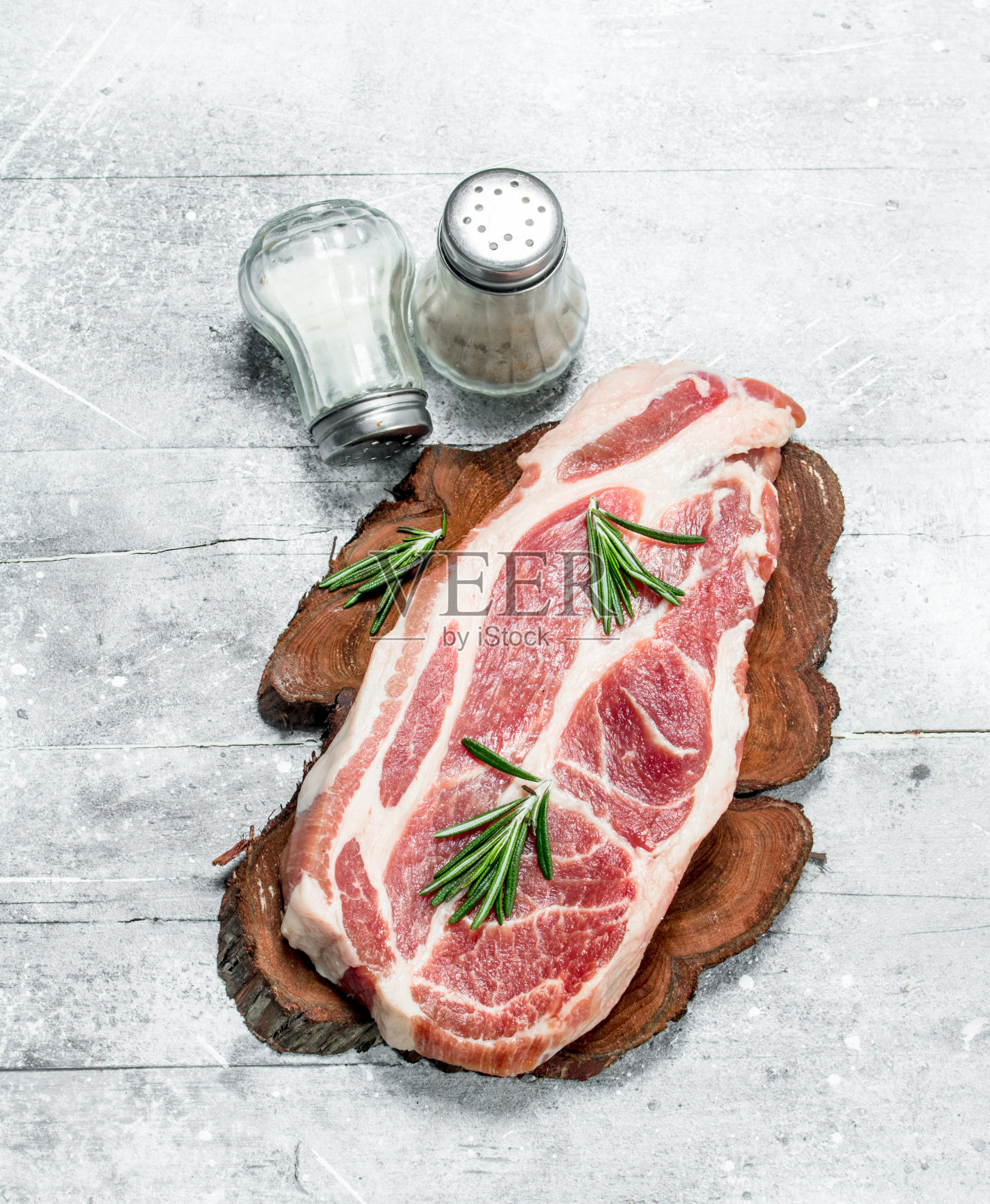 生猪肉排配迷迭香和香料。照片摄影图片