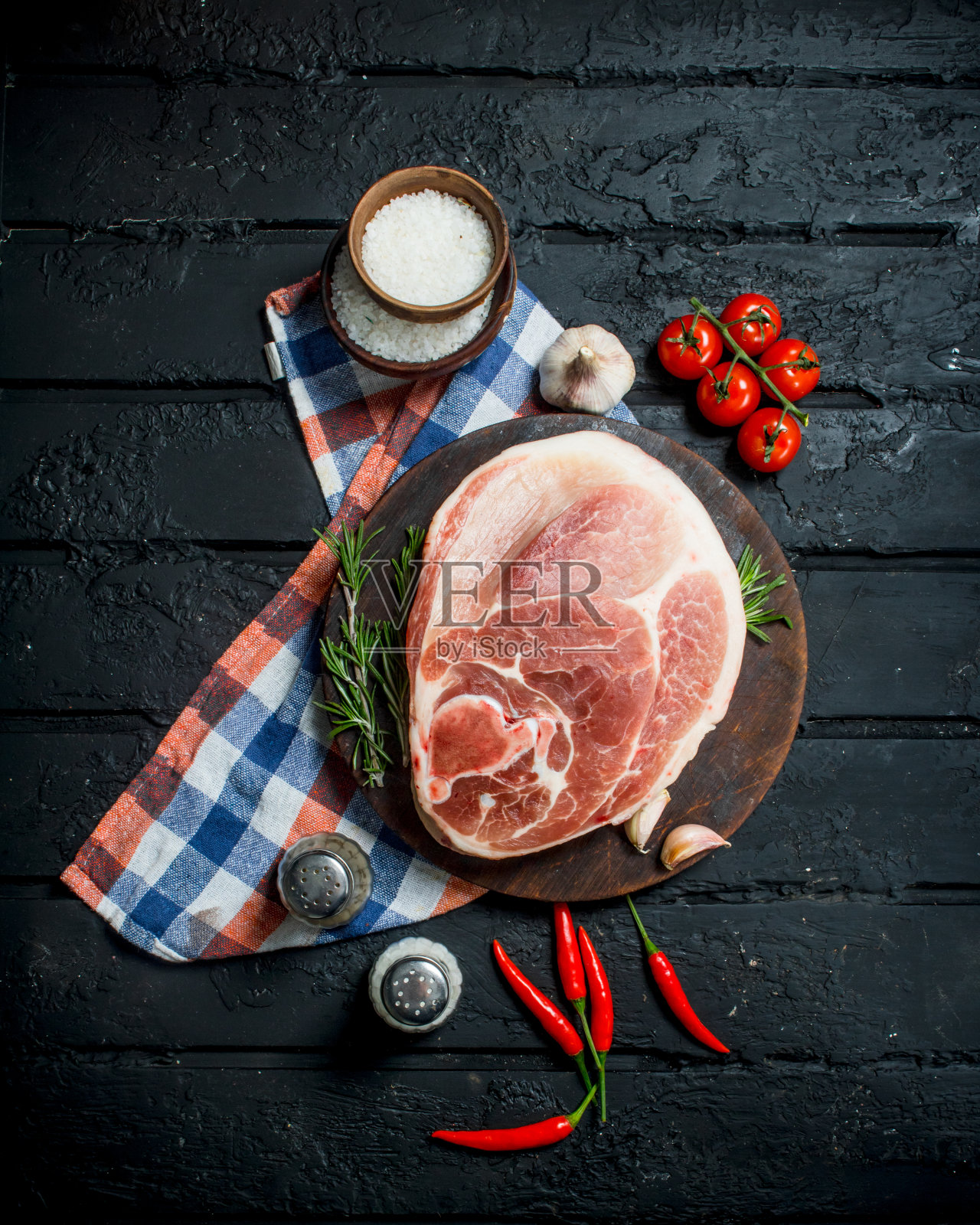 大的生猪肉排配上香料和蔬菜。照片摄影图片