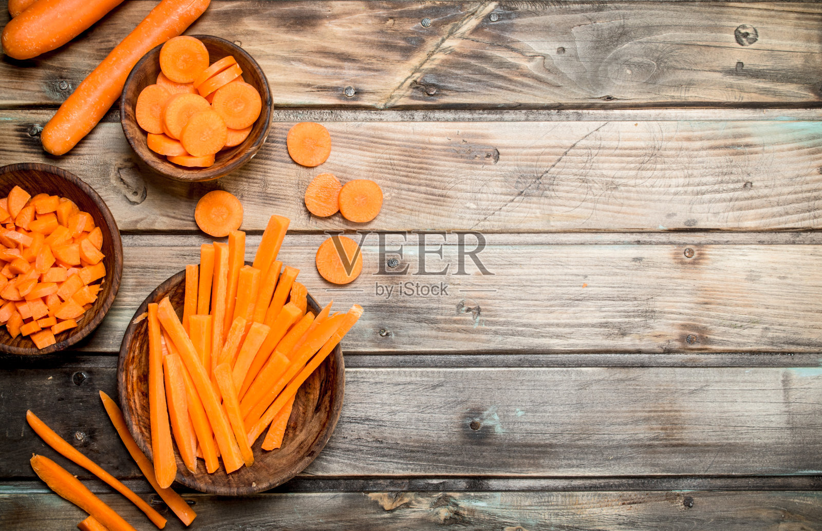 把新鲜的胡萝卜片放在碗里。照片摄影图片