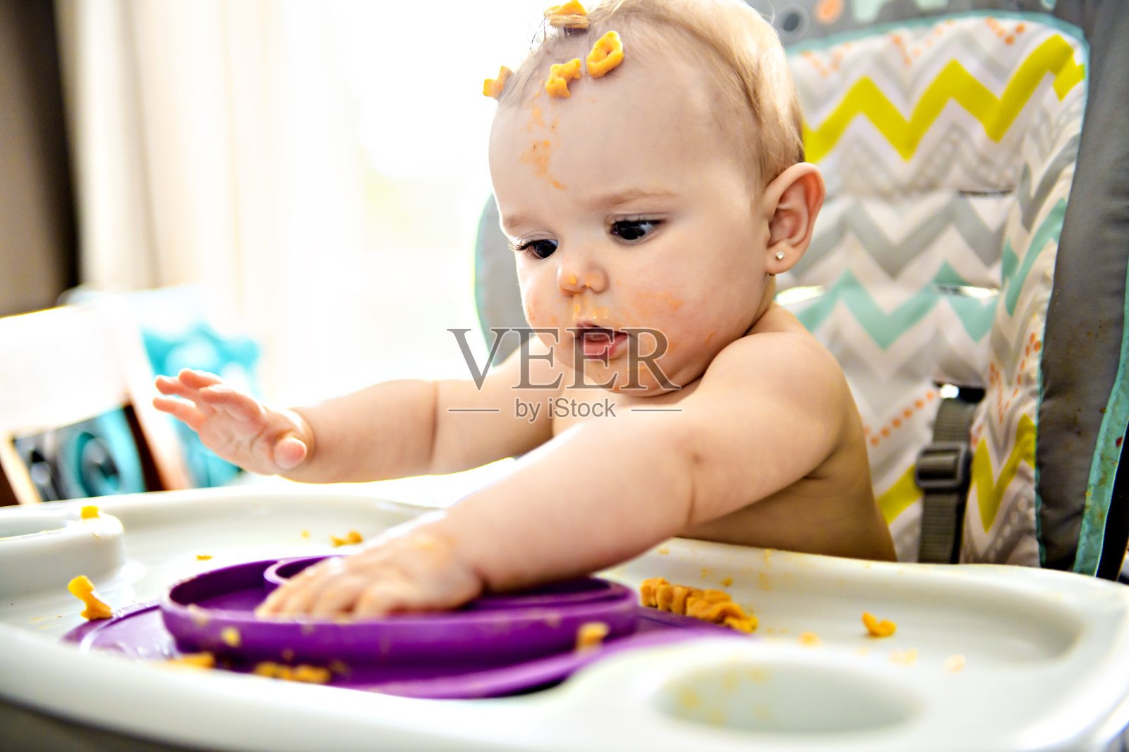 小婴儿在吃她的晚餐，弄得一团糟照片摄影图片